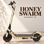 HONEY SWARM für Ninebot E3: creme- und bernsteinfarbene Waben mit kleinen Bienenpaaren. Originale graue Trittmatte mit rotem Ninebot-Schriftzug bleibt erhalten. Designvisualisierung.