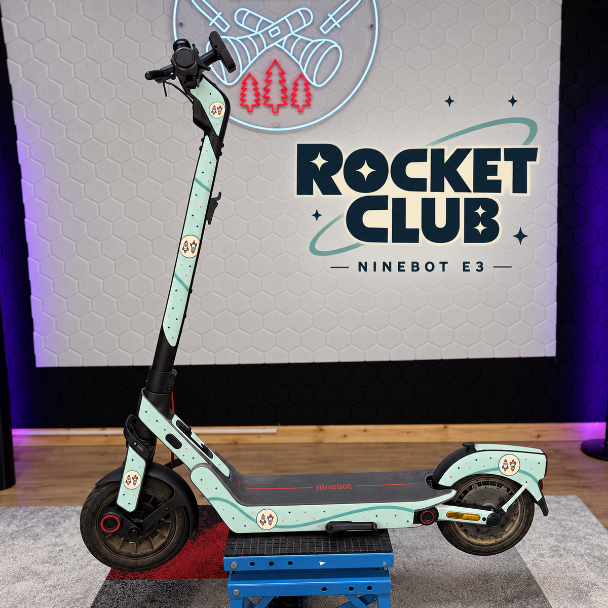 Ninebot E3 mit ROCKET CLUB Skin: Mint, kleine Sterne und runde Abzeichen mit zwei Retro-Raketen. Originale Trittmatte erhalten.