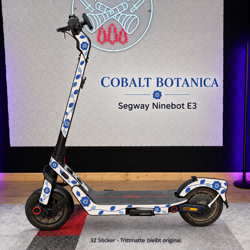 COBALT BOTANICA Designansicht für Segway Ninebot E3: elfenbeinfarbenes Skin mit kobaltblauen Blüten und Blättern; graue Original-Trittmatte bleibt erhalten.